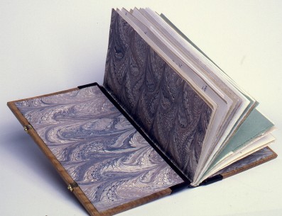 The paste downs and fly leaves are of acrylic marbled paper backed onto silk. The hinges of green silk backed to paper.