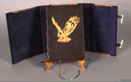 Book cover of dark brown leather over five double raised bands. The eagle is variegated copper on a leather pad and pressed into the cover.