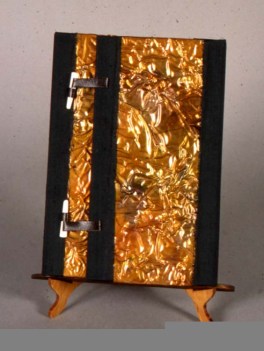 I was asked by the owner of Eagle Eye Gallery in Seattle to do something "Post Modern". This is the wrapper for the book. Silk, stressed copper, bone latches w/leather ties. The stand was hand made of oak, by me too. Needless to say he was very surprised.