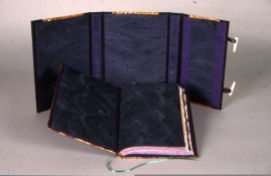 The inside of the wrapper of hand painted silk (green silk w/purple waves. The same silk was used for the paste-downs & the fly leaves (backed to moriki mulberry paper)